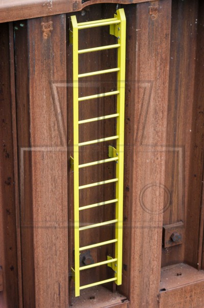 gelbe Leiter in der rostigen Kaimauer
